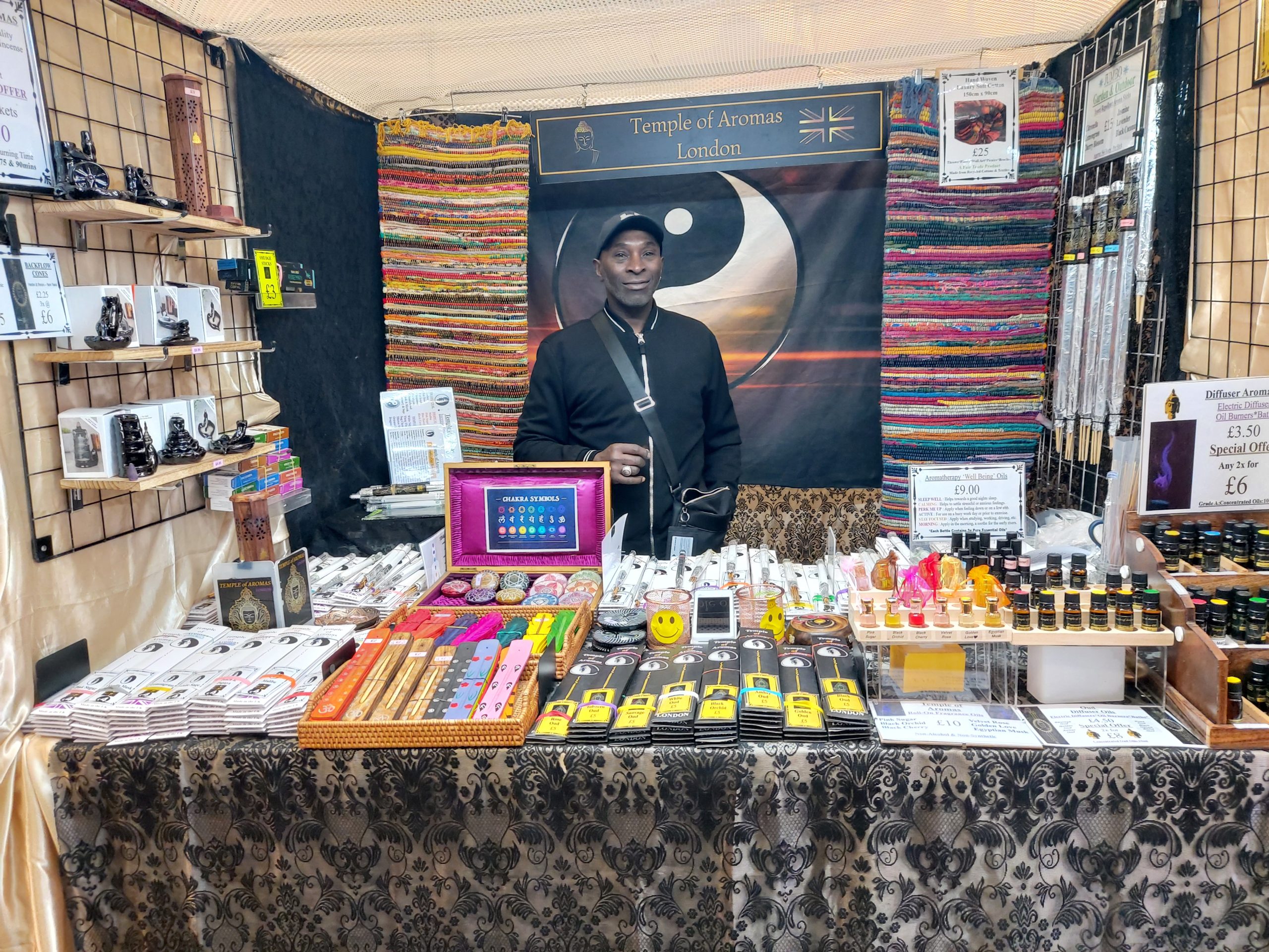 A vendor at a London craft market standing in a well-organized stall 
